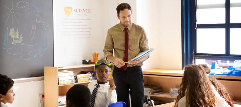 Male teacher leading a Science class in school