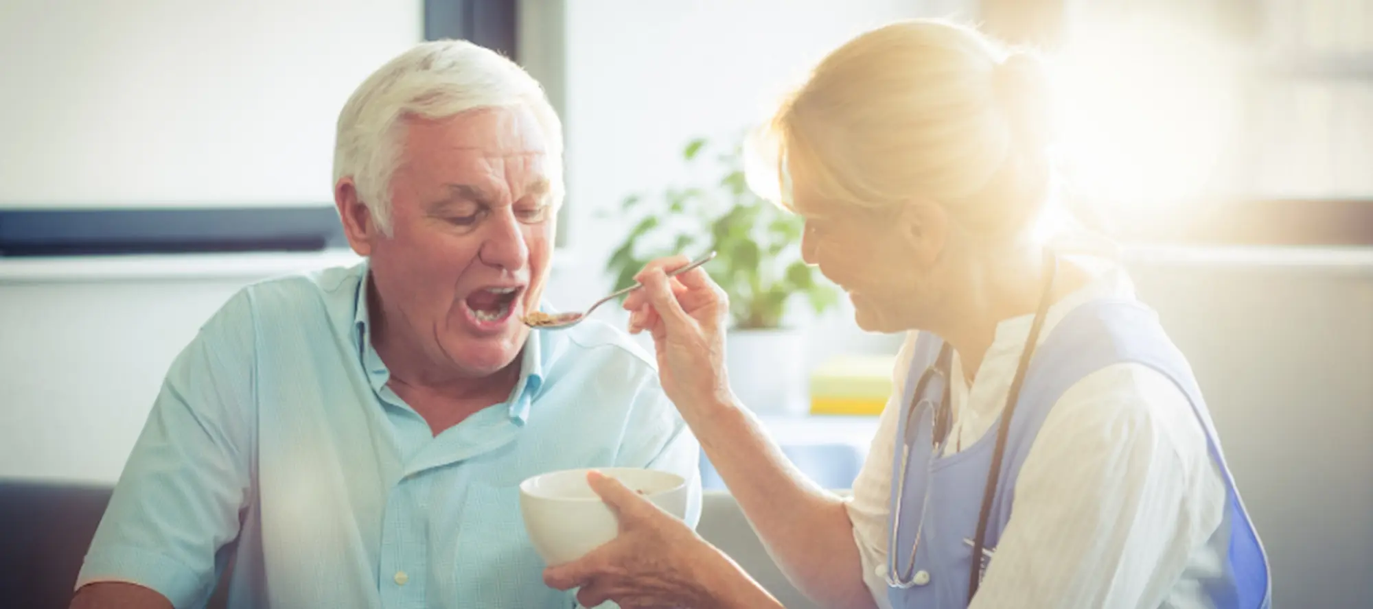 Carer feeding elderly patient